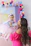 A joyful mom-to-be surrounded by pastel-colored balloons and baby shower decorations.