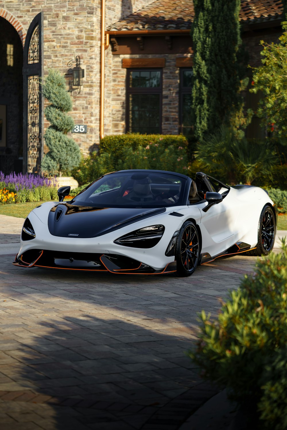 a white sports car parked in front of a brick building