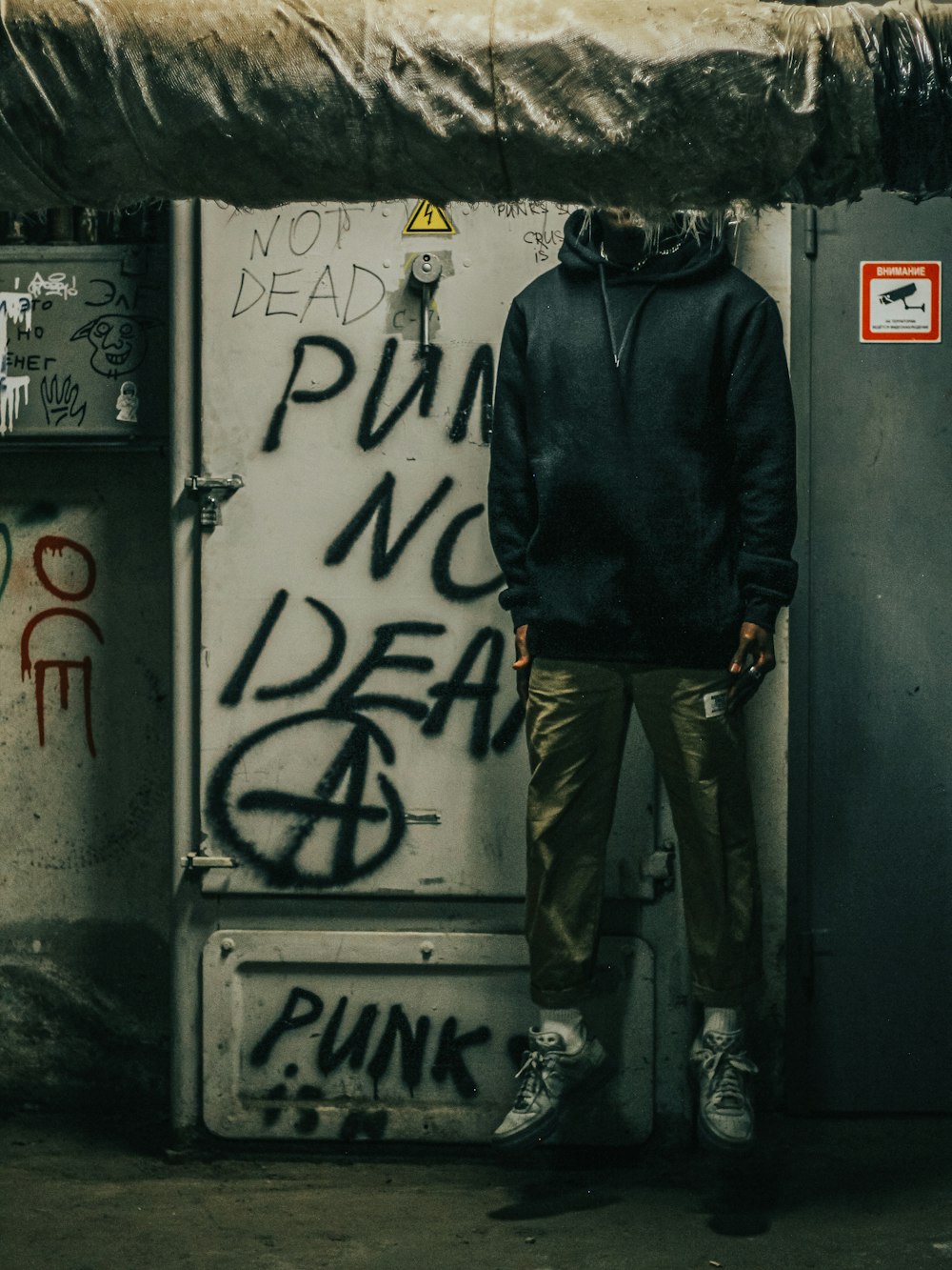 a person standing in front of a door with graffiti on it