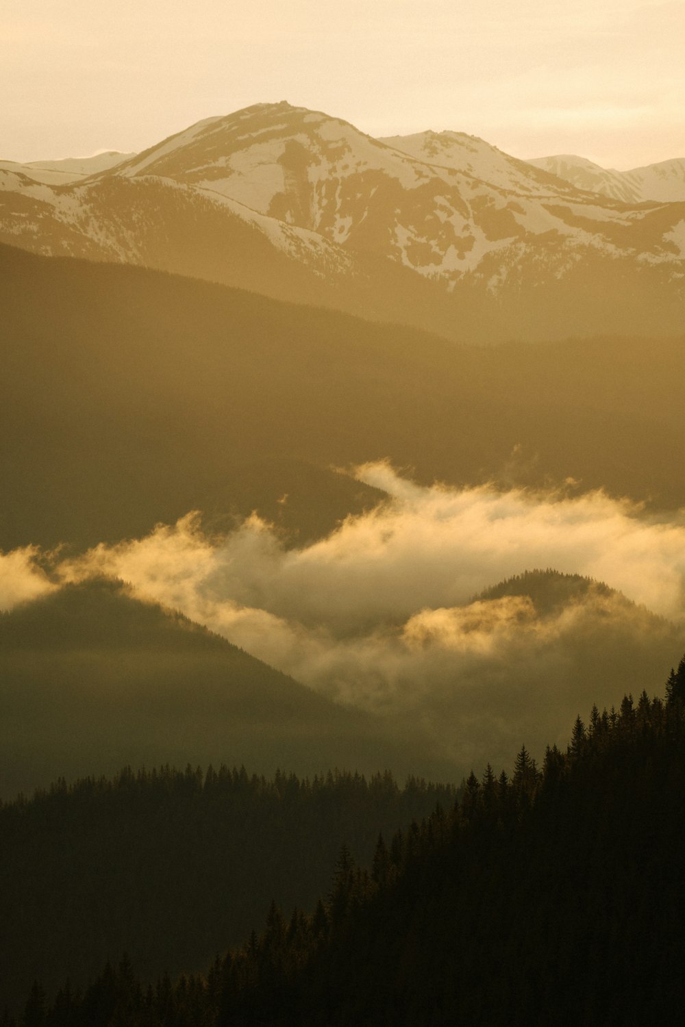 a mountain with clouds below