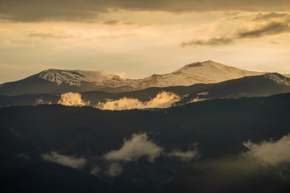 a mountain range with clouds below