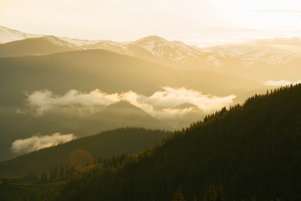 a view of a mountain range with clouds below