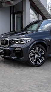 A sleek SUV parked outside an airport terminal ready for pickup.