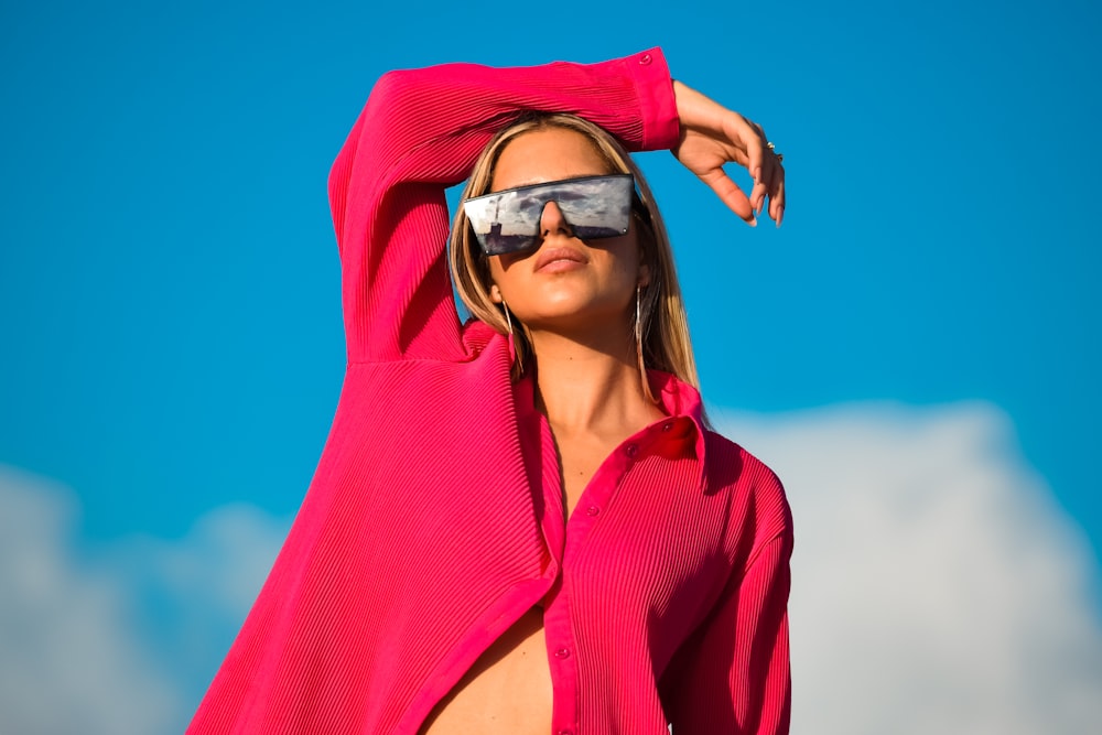a woman wearing a red hoodie and sunglasses