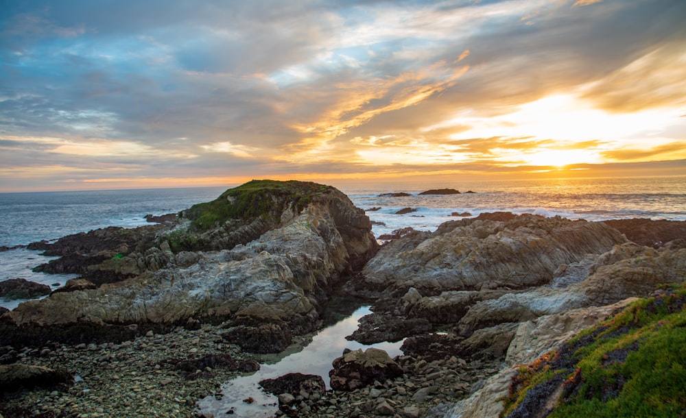 a rocky beach with a sunset