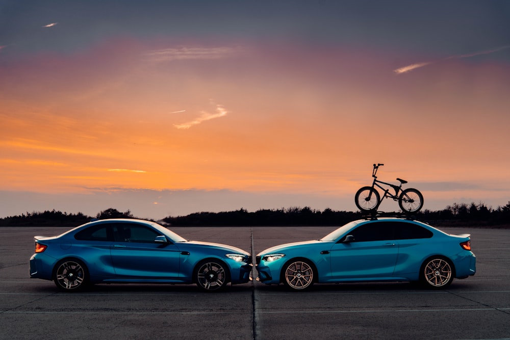 a couple of cars parked in a parking lot with a bicycle on top of it