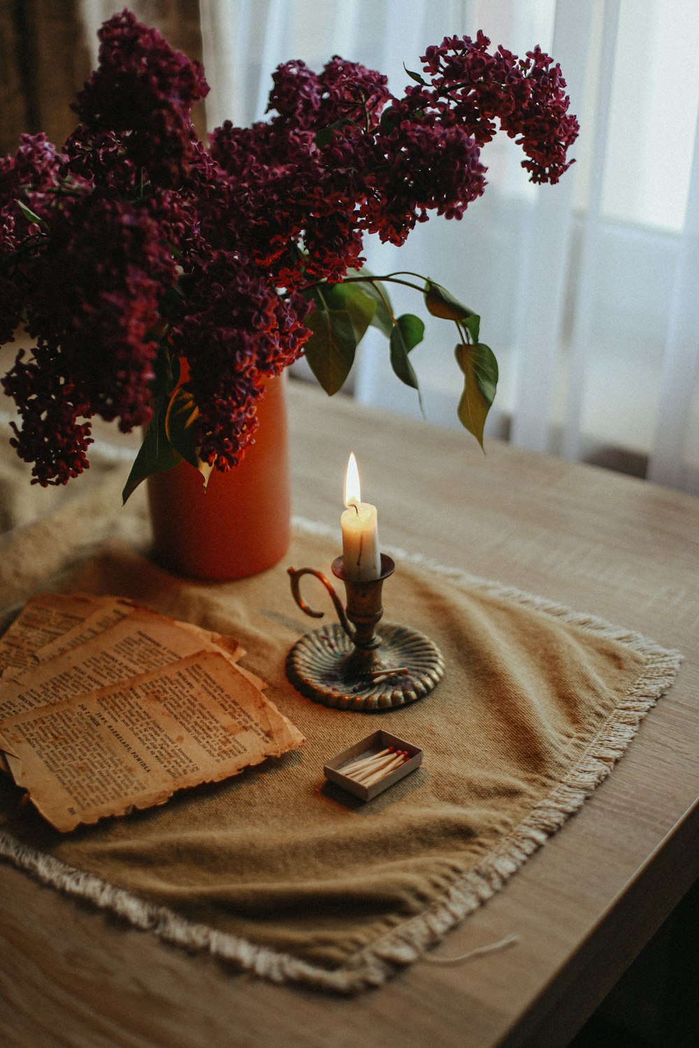 a candle and a vase of flowers