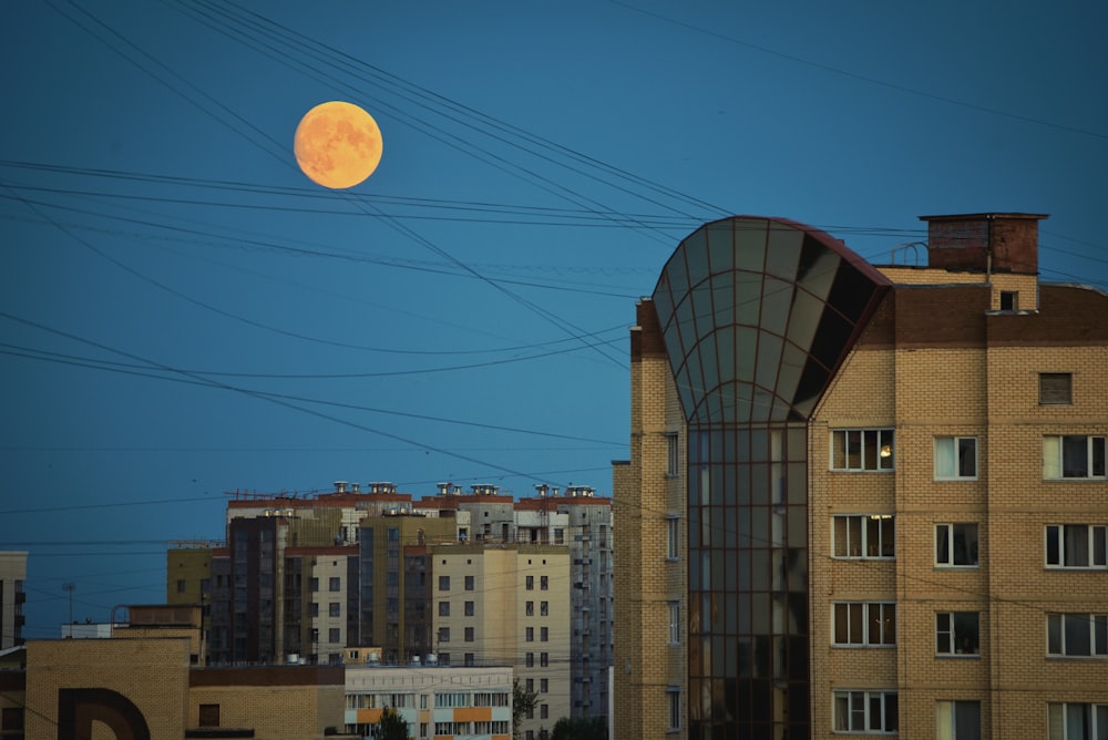a group of buildings with a moon in the sky