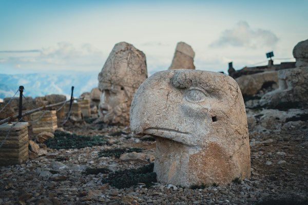 A group of large rocks with Mount Nemrut in the background