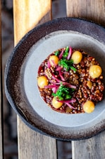 A vibrant overhead shot of a colorful spiced lentil dish garnished with fresh herbs and a side of warm naan bread.