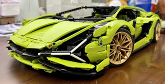 A colorful metal model car built from classic construction set pieces on a wooden table.