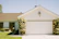 Smiling homeowner standing proudly in front of their newly converted garage ADU with fresh paint and landscaping.