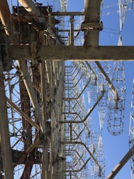 A large, complex metal structure with intricate latticed frameworks extending vertically into the sky. Several large metal beams and supports are interconnected, creating an industrial appearance.
