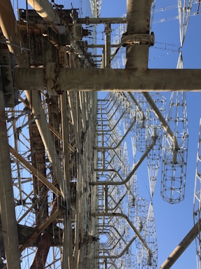 A large, complex metal structure with intricate latticed frameworks extending vertically into the sky. Several large metal beams and supports are interconnected, creating an industrial appearance.