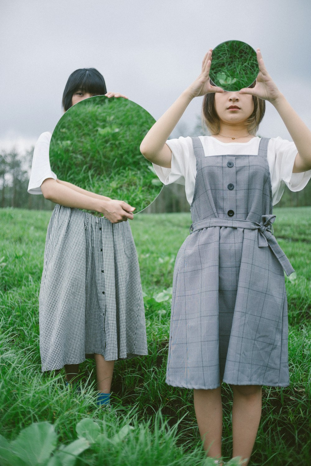 two girls wearing dresses and holding their hands up