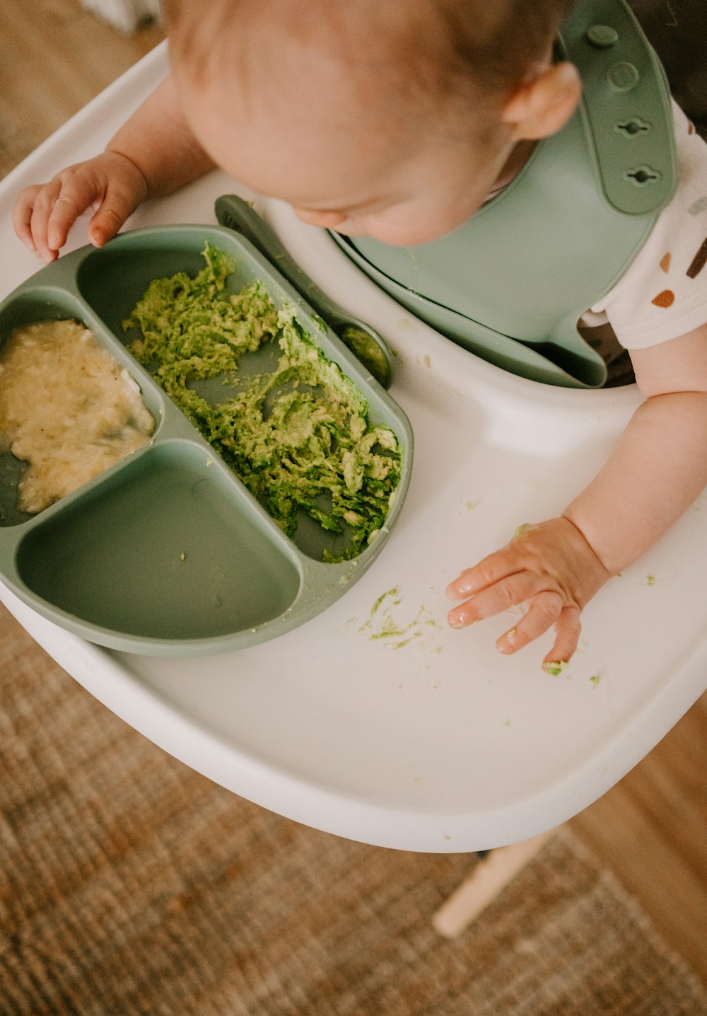 a baby eating broccoli