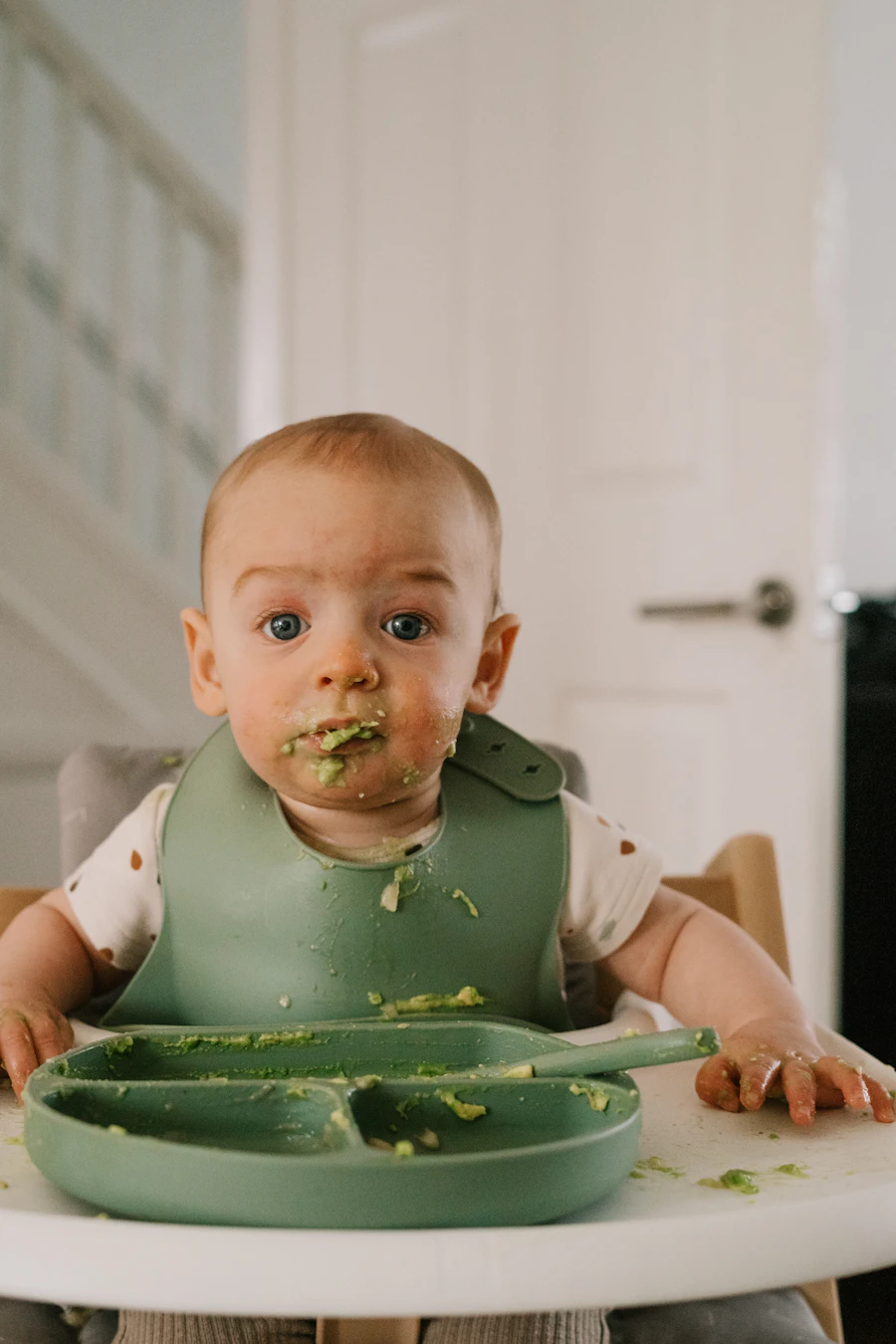 Bebé comiendo con cubiertos infantiles