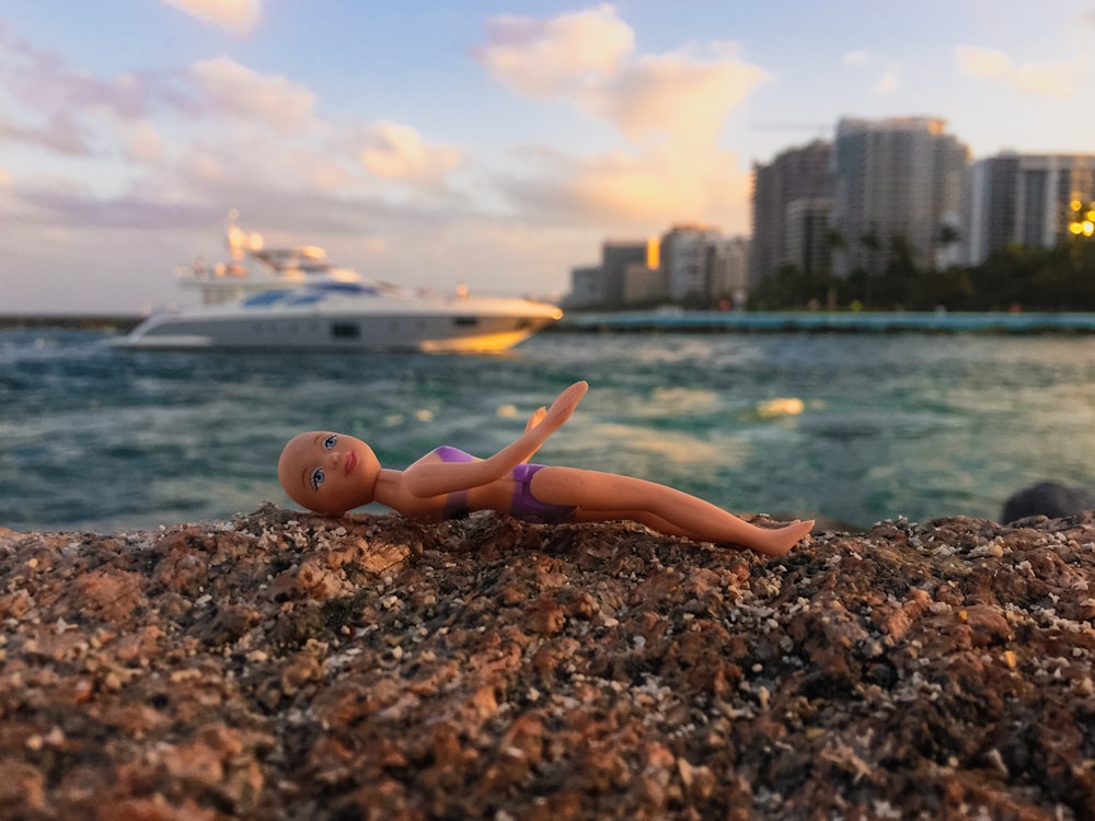 a toy mermaid on a rocky beach
