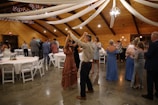a man and woman dancing in a room with tables and chairs
