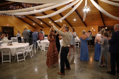 a man and woman dancing in a room with tables and chairs