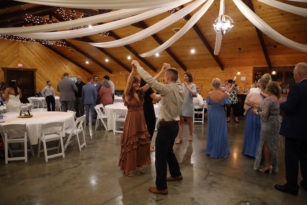 a man and woman dancing in a room with tables and chairs