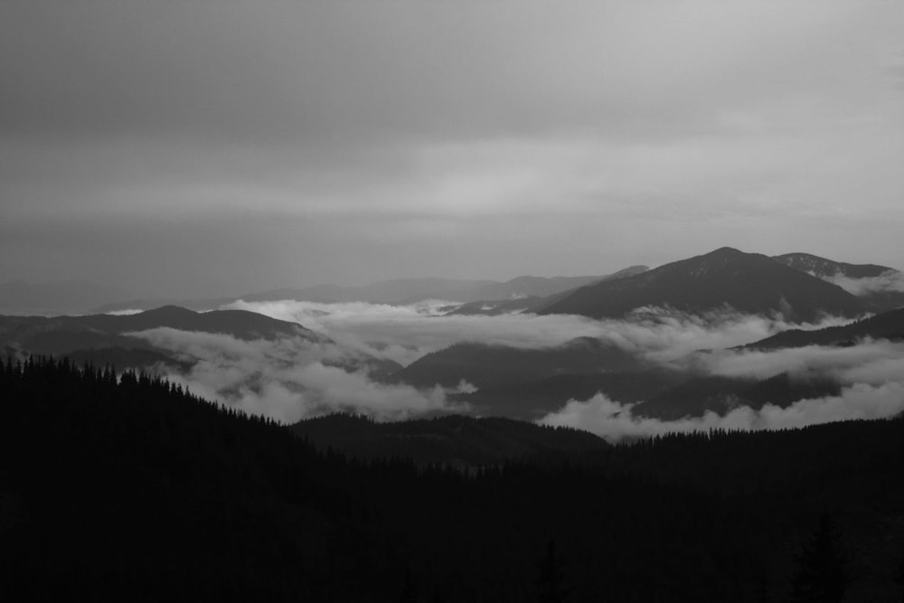 a view of a mountain range with clouds and fog