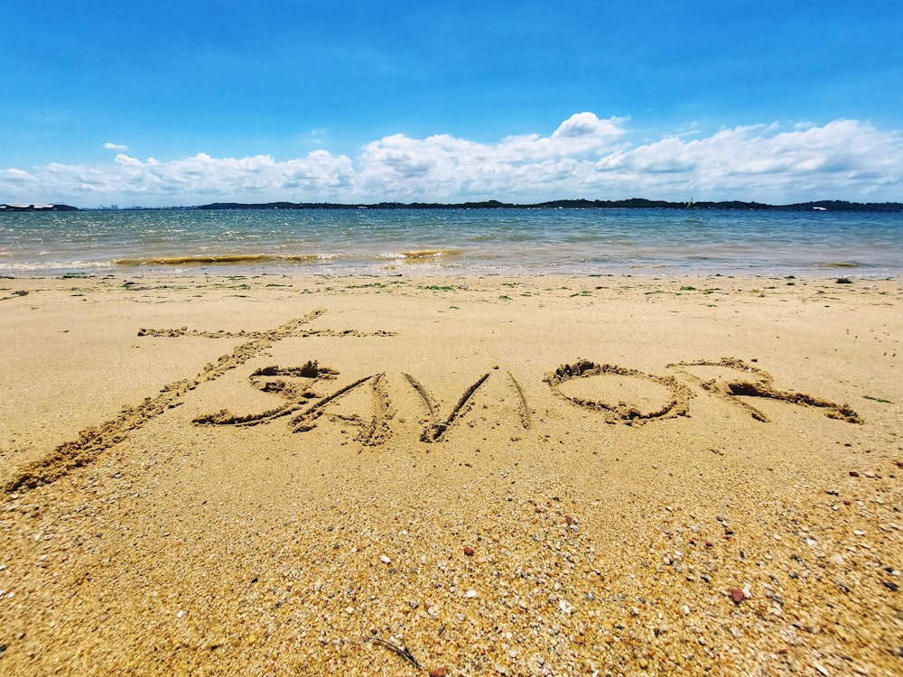 a beach with writing in the sand