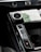 A close-up view of a car's center console featuring a digital temperature control knob set at 22 degrees, gear shift buttons labeled D, N, R, and P, and part of a touchscreen interface displaying seat and climate settings.