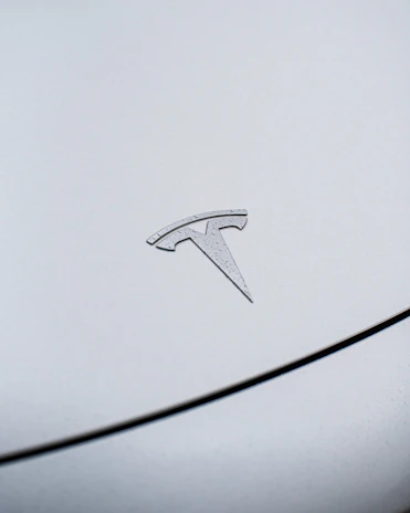 Detail of a Tesla badge on a car freshly repaired and polished, highlighting EV certification.