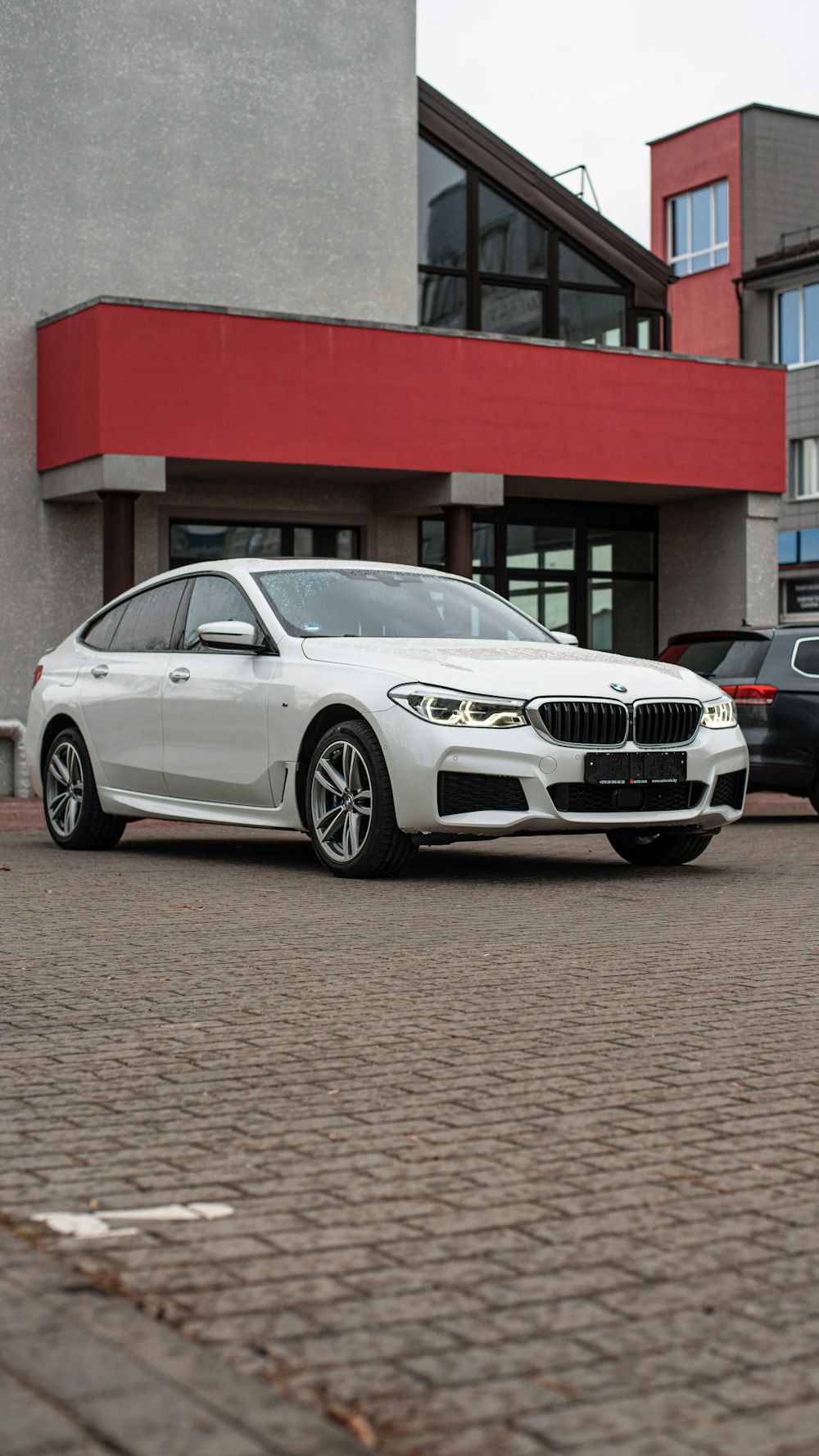 a white car parked in front of a building