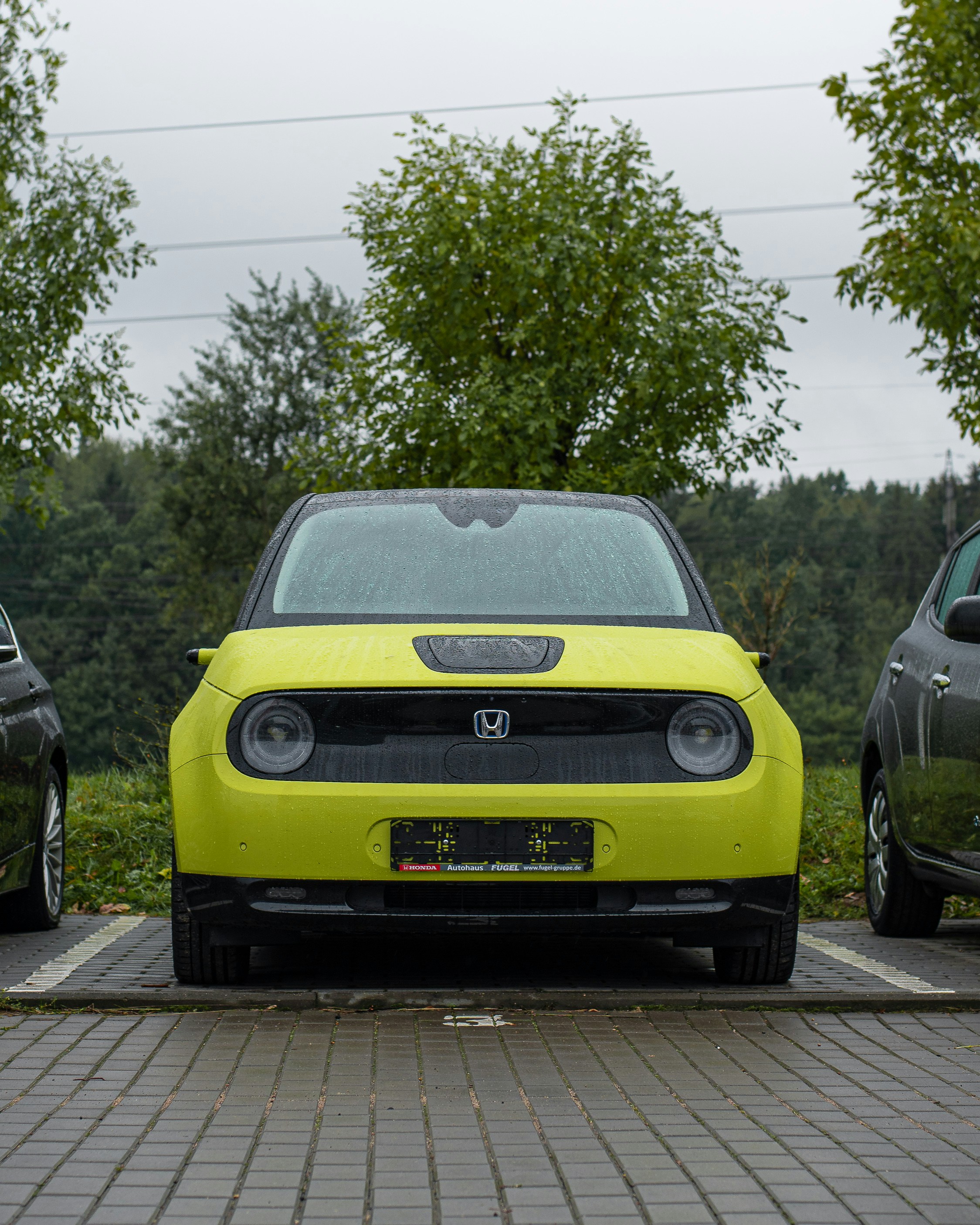 a yellow car parked on a brick road