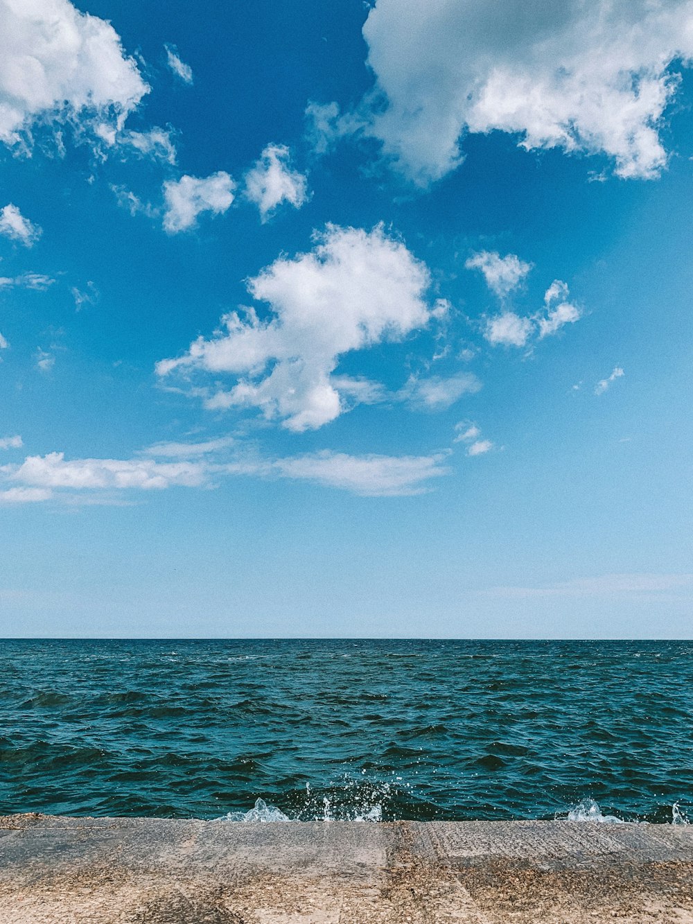 um corpo de água com uma praia e céu azul