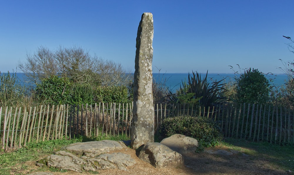 a stone pillar in a fenced yard