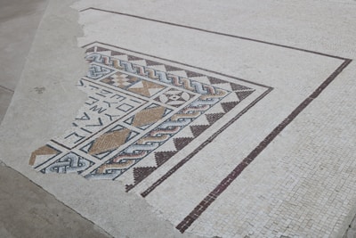 Floor covered with geometric mosaic tiles in warm earthy tones
