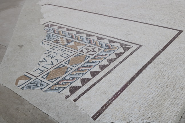 Close-up of a freshly installed intricate mosaic tile floor in a cozy living room.