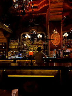 A warm, inviting bar interior featuring rustic wooden accents, leather seating, and Texas-themed decor under soft ambient lighting.