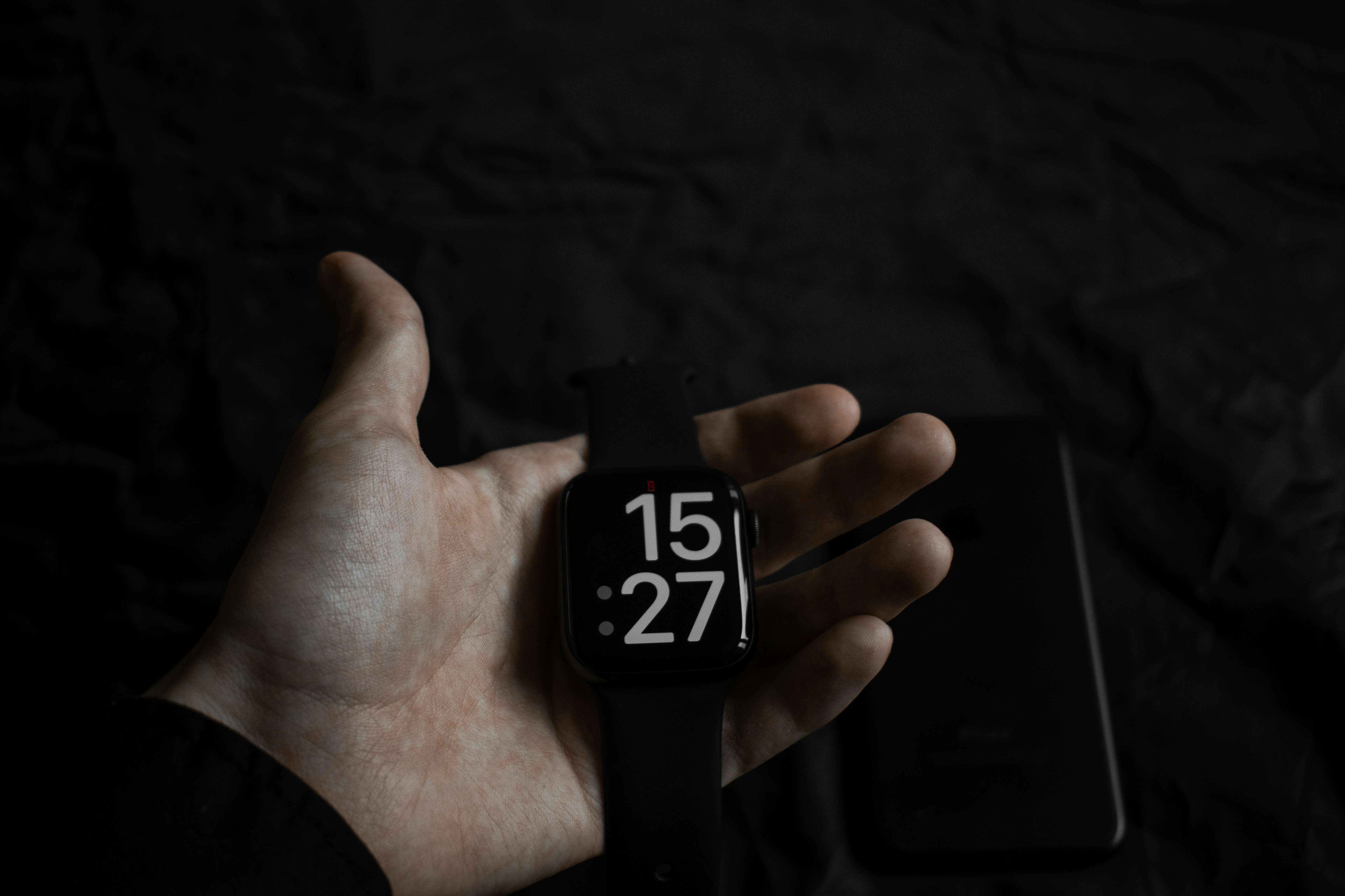 a hand holding a small black and silver lighter