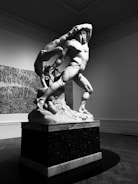 Marble sculpture capturing fluid human movement in soft light.