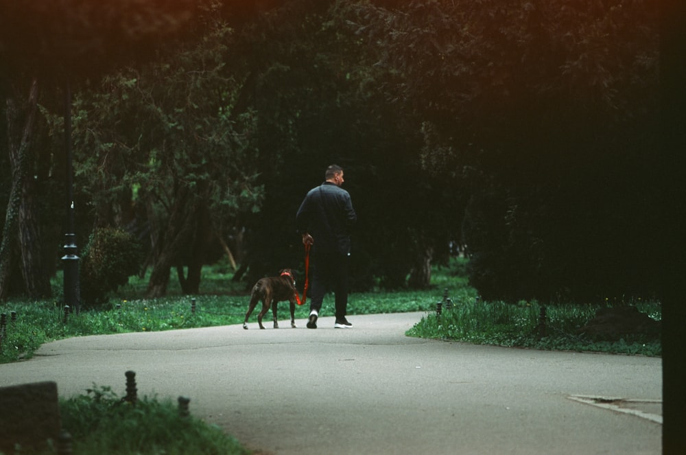 Un uomo che cammina un cane al guinzaglio