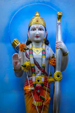 A vibrant illustration of Manmatha wielding his sugarcane bow, surrounded by blooming flowers.