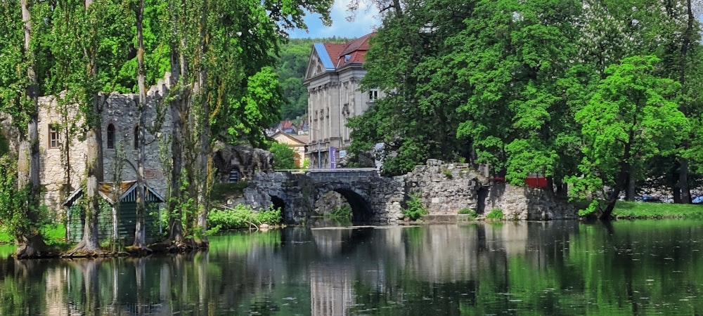 a stone bridge over a body of water with trees on either side