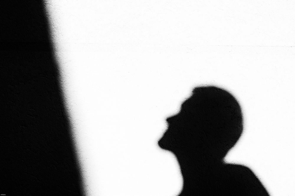 a person's shadow on a white surface