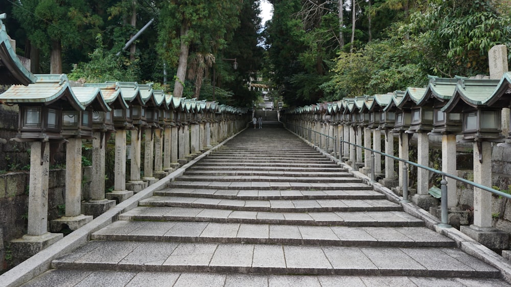 a stone bridge with pillars and a building in the background