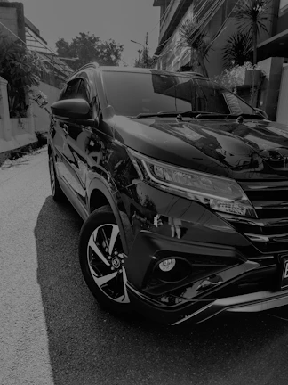 Wide angle of a shiny SUV parked outdoors with a mirror-like finish.