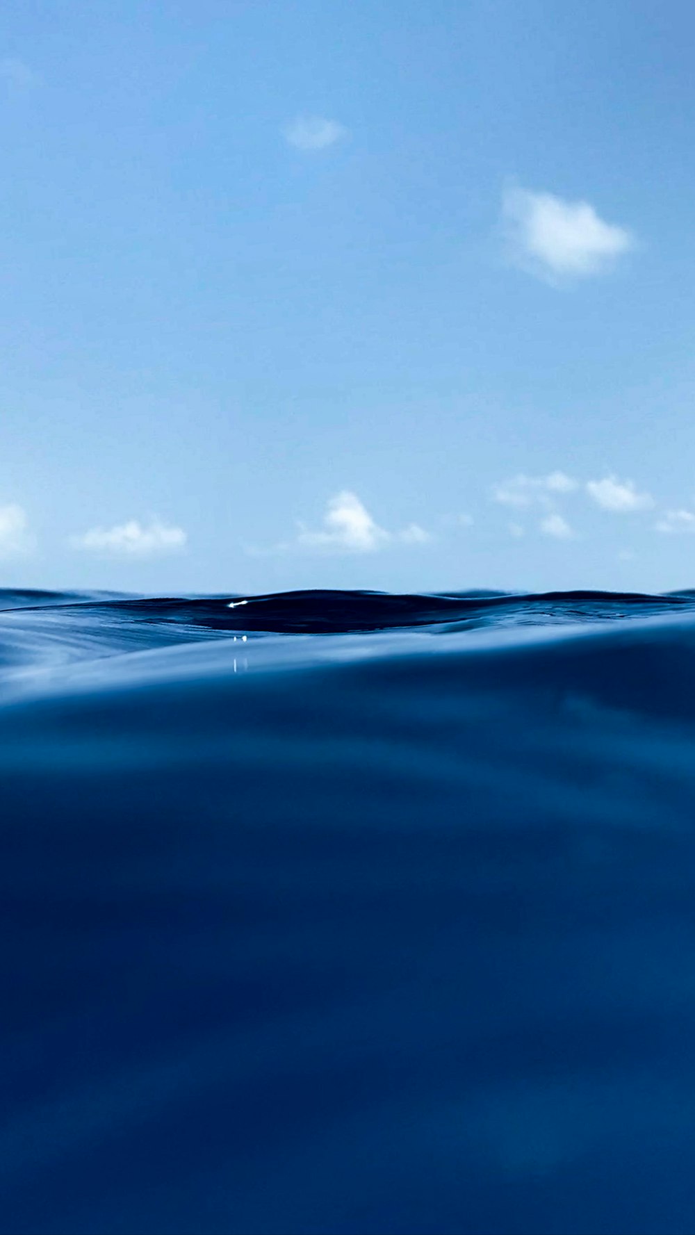 a body of water with a blue sky and clouds