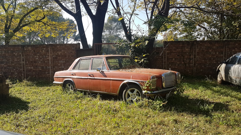 an old rusted car in a yard