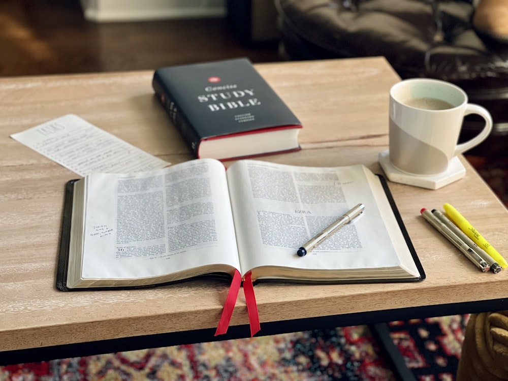 Un libro y una taza de café sobre una mesa