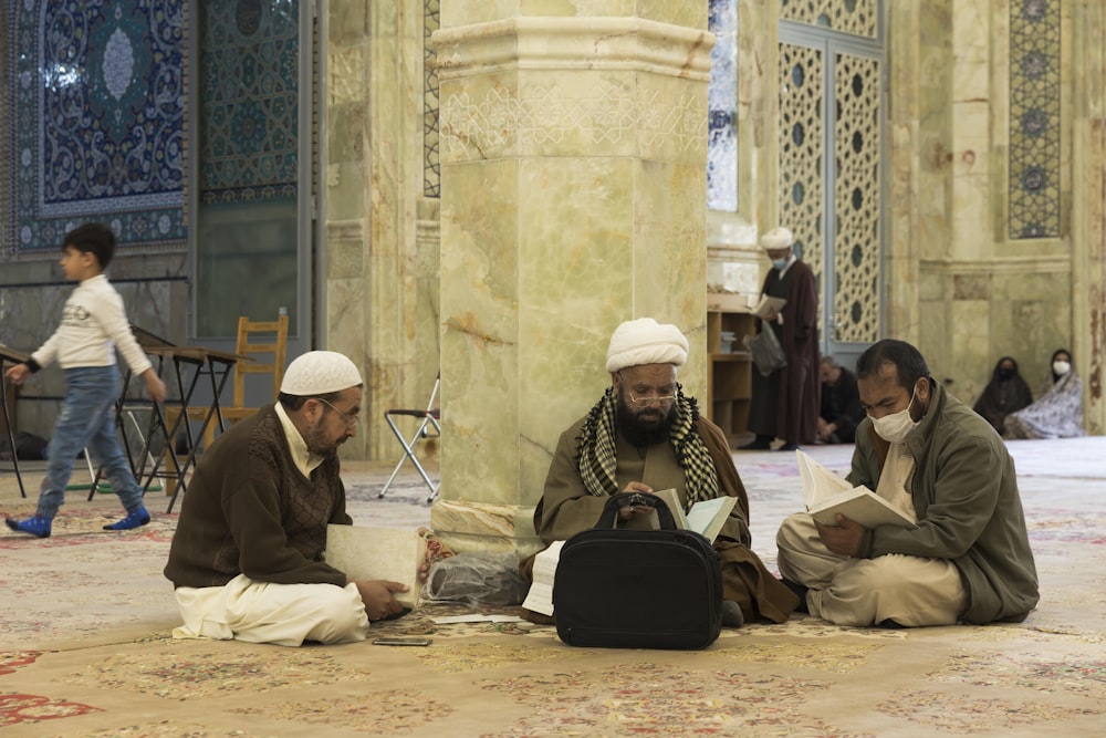 a group of men sitting on the floor of a mosque