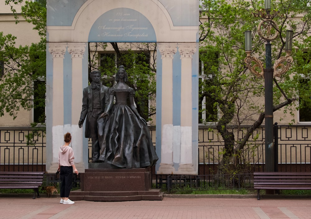 une personne debout à côté d’une statue