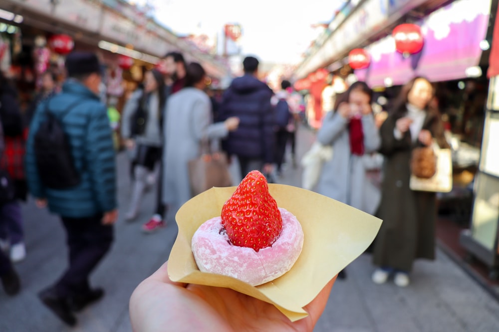 a hand holding a cupcake